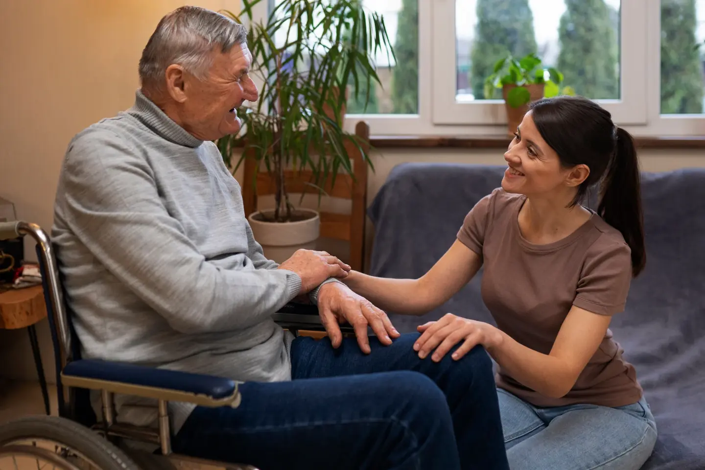 Old man sat with carer at home