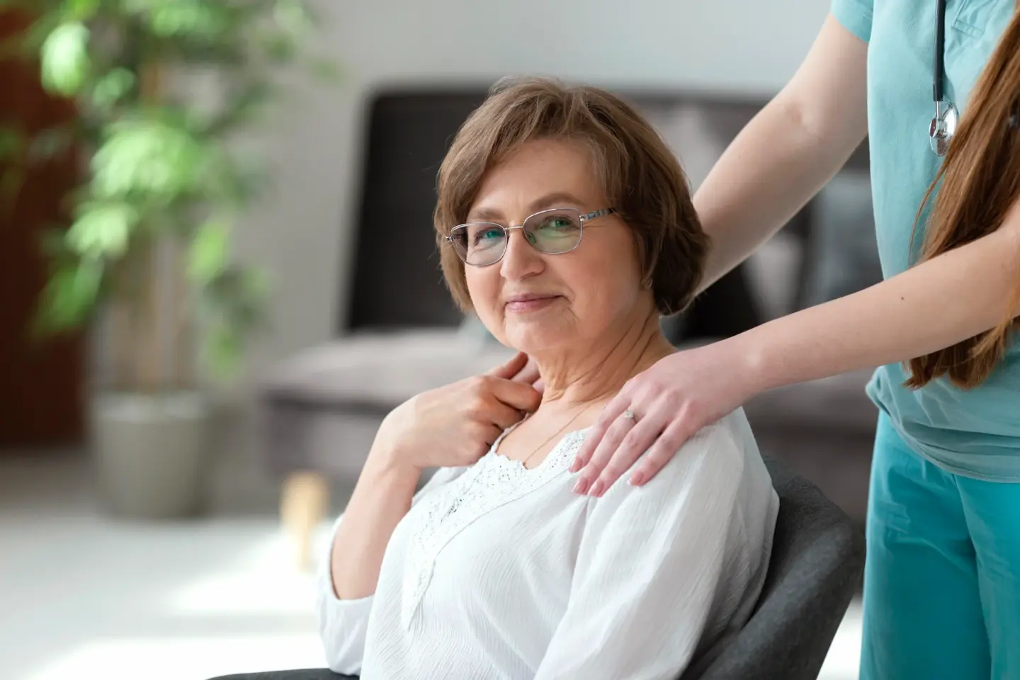 close up elderly woman sitting in chair with carer