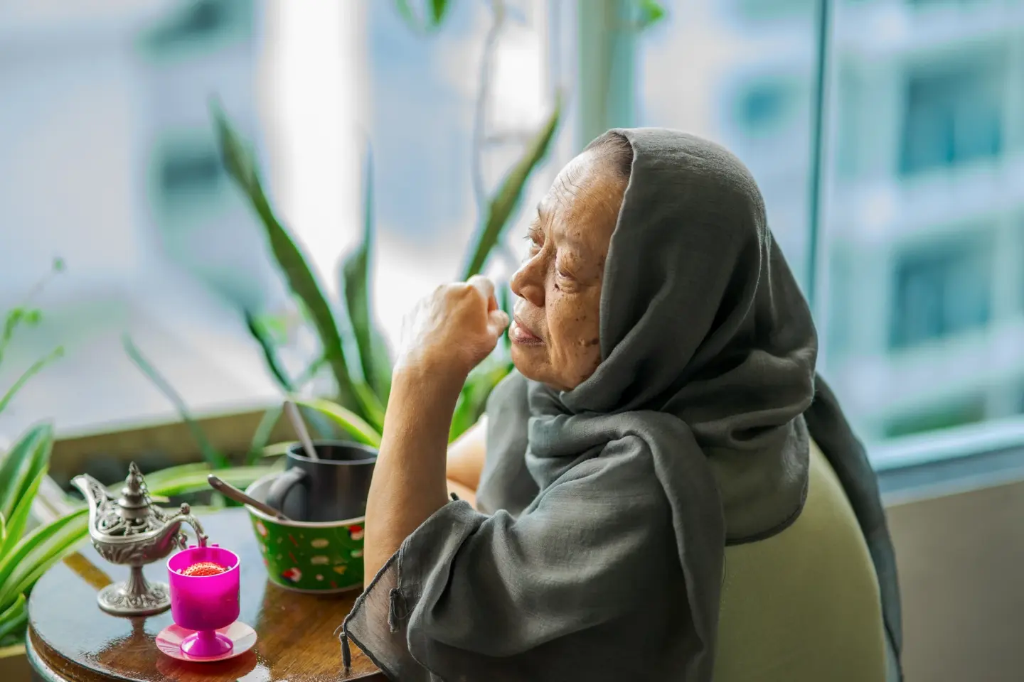 senior woman wearing hijab sitting at the balcony